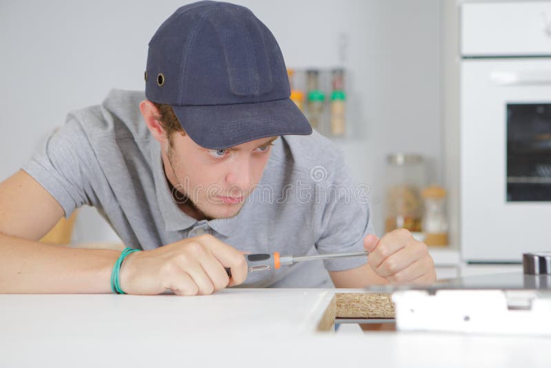 Jeune entrepreneur travaillant dans la cuisine photo stock Jeune entrepreneur travaillant dans la cuisine photo stock