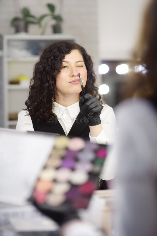 Jeune esthéticien ayant l'amusement pendant le travail dans un salon de beauté photographie stock libre de droits Jeune esthéticien ayant l'amusement pendant le travail dans un salon de beauté photographie stock libre de droits