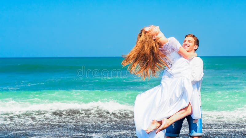 Jeune famille heureuse des vacances de plage de lune de miel image stock Jeune famille heureuse des vacances de plage de lune de miel image stock