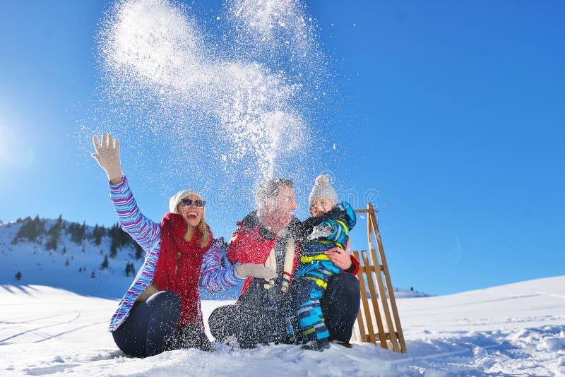 Jeune famille heureuse jouant dans la neige fraîche au beau jour d'hiver ensoleillé extérieur en nature image libre de droits Jeune famille heureuse jouant dans la neige fraîche au beau jour d'hiver ensoleillé extérieur en nature image libre de droits