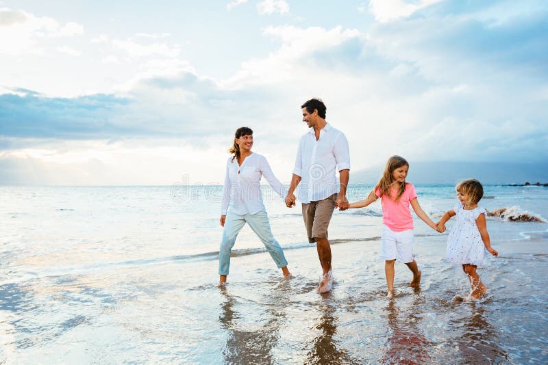 Jeune famille heureuse marchant sur la plage photos libres de droits