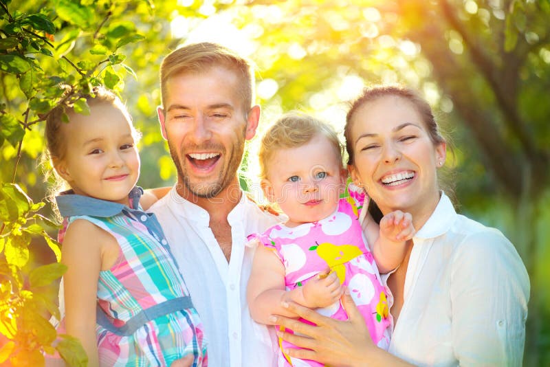 Jeune famille joyeuse heureuse avec de petits enfants dehors photo stock Jeune famille joyeuse heureuse avec de petits enfants dehors photo stock