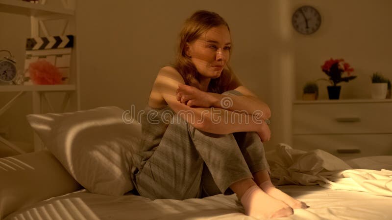 Jeune femme abandonnée s'asseyant sur le lit et la solitude pleurante de douleur, regret images libres de droits Jeune femme abandonnée s'asseyant sur le lit et la solitude pleurante de douleur, regret images libres de droits
