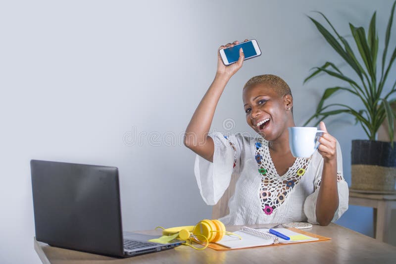 Jeune femme afro-américaine noire heureuse et attirante de hippie travaillant à la maison le bureau avec l'ordinateur portable ut photos stock Jeune femme afro-américaine noire heureuse et attirante de hippie travaillant à la maison le bureau avec l'ordinateur portable ut photos stock