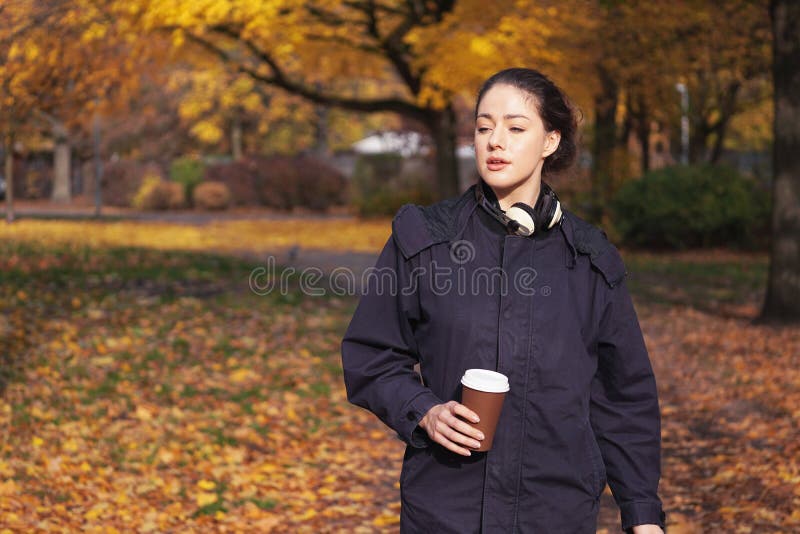 Jeune femme appréciant la promenade par le parc en automne image libre de droits Jeune femme appréciant la promenade par le parc en automne image libre de droits