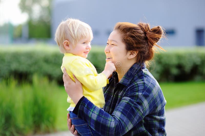 Jeune femme asiatique avec le garçon caucasien mignon d'enfant en bas âge image stock Jeune femme asiatique avec le garçon caucasien mignon d'enfant en bas âge image stock