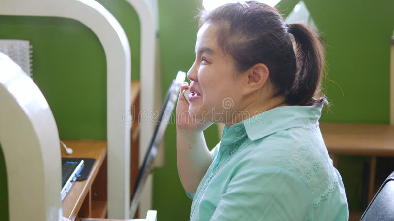 Jeune femme asiatique de personne aveugle souriant en utilisant le téléphone intelligent avec des technologies d'assistance aux u