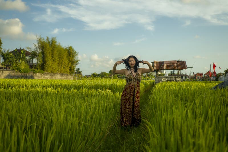 Jeune femme asiatique heureuse et belle profitant de la nature sur le terrain du riz adorable coréenne à explorer la campagne pen photo libre de droits Jeune femme asiatique heureuse et belle profitant de la nature sur le terrain du riz adorable coréenne à explorer la campagne pen photo libre de droits