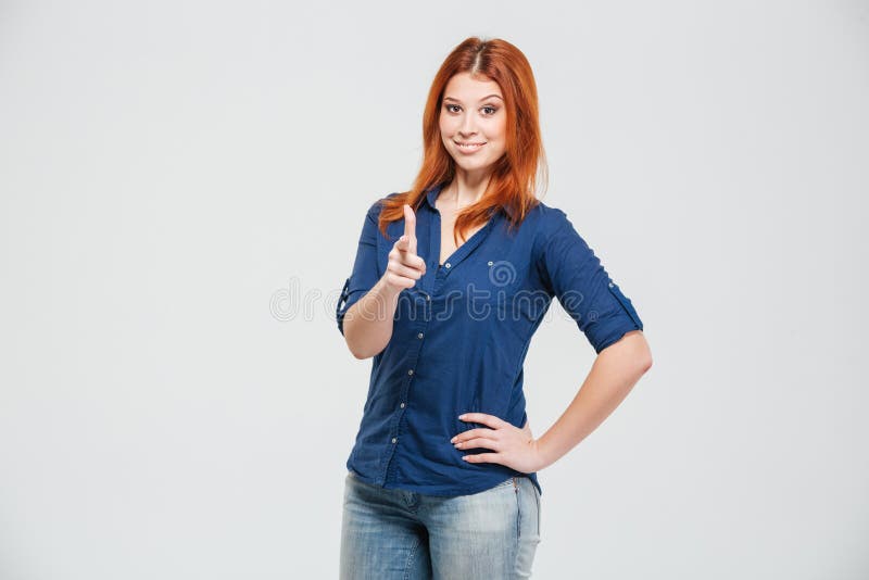 Jeune femme assez rousse heureuse se tenant et se dirigeant sur vous images libres de droits Jeune femme assez rousse heureuse se tenant et se dirigeant sur vous images libres de droits