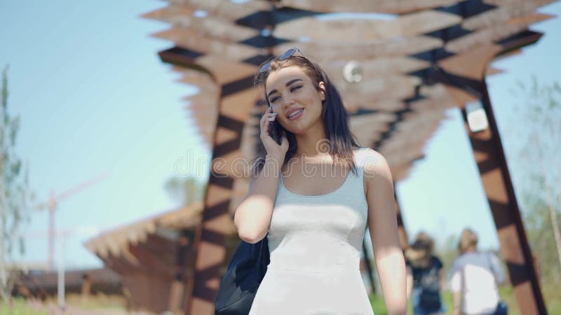 Jeune femme attirante avec téléphone portable appelle banque de vidéos