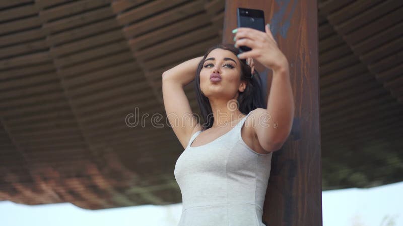 Jeune femme attirante faisant le selfie clips vidéos