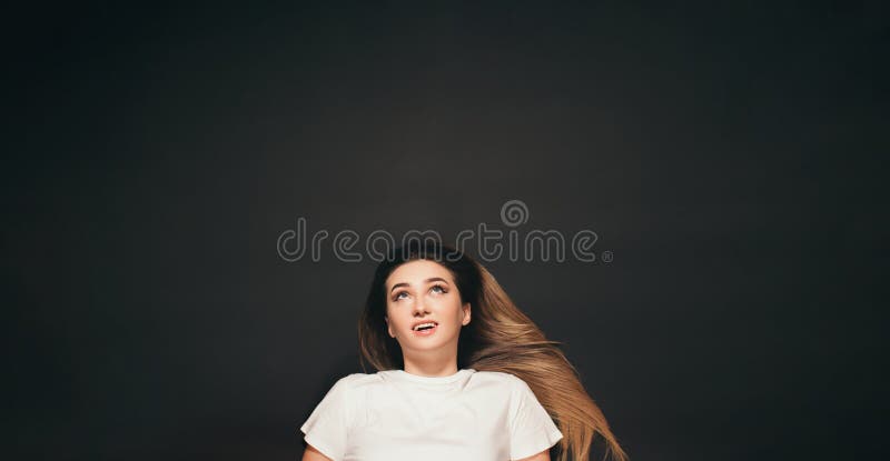 Jeune femme aux cheveux longs couché avec les émotions sur l'étudiant de visage sur le fond du conseil scolaire noir images stock