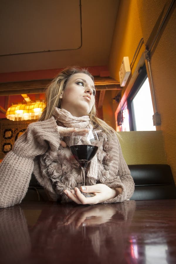 Jeune femme avec de beaux yeux bleus buvant du vin rouge image stock Jeune femme avec de beaux yeux bleus buvant du vin rouge image stock