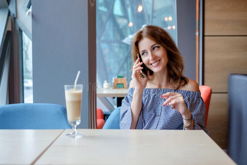 Jeune femme avec du charme appelant avec le téléphone de cellules tout en seul se reposant dans le café, femelle attirante avec l photographie stock Jeune femme avec du charme appelant avec le téléphone de cellules tout en seul se reposant dans le café, femelle attirante avec l photographie stock