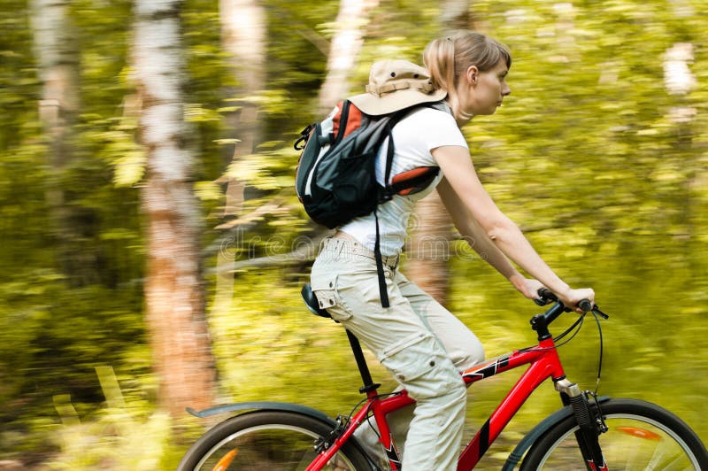 Jeune femme avec la bicyclette dans la forêt