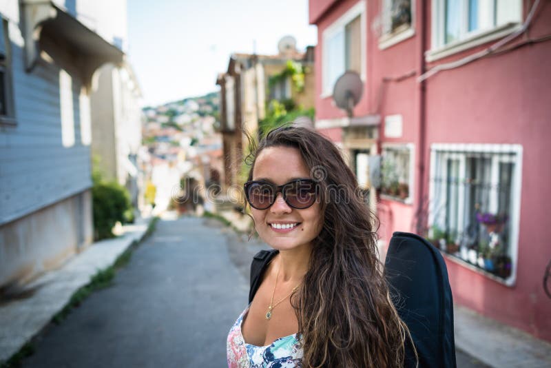 Jeune femme avec la caisse pour un instrument de musique sur le dos photos stock Jeune femme avec la caisse pour un instrument de musique sur le dos photos stock