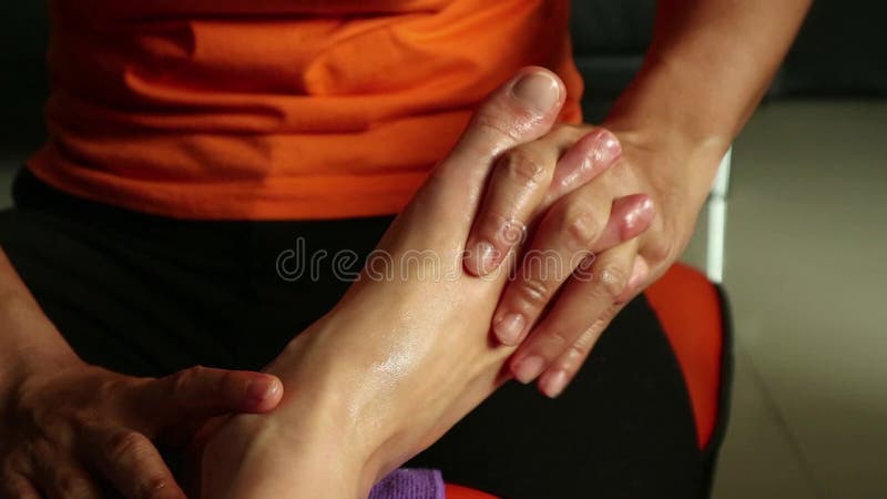 Jeune femme ayant le massage de pieds dans le salon de station thermale de beauté jambes en gros plan du ` s de femme et mains du