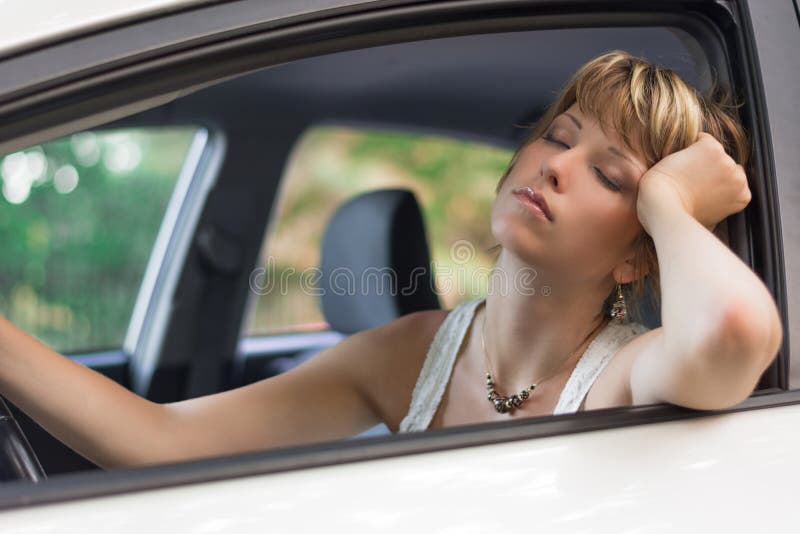 Jeune femme blonde attirante dormant dans une voiture images libres de droits Jeune femme blonde attirante dormant dans une voiture images libres de droits