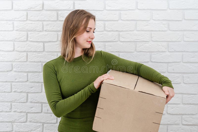 Jeune femme blonde avec boîte de colis. livraison d'un colis photo stock