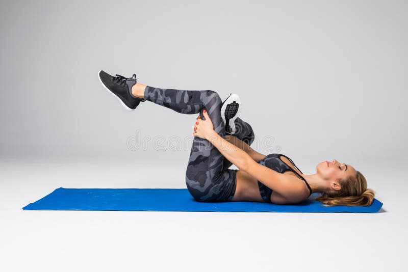 Jeune femme blonde en bonne santé faisant des craquements sur le fond gris images libres de droits Jeune femme blonde en bonne santé faisant des craquements sur le fond gris images libres de droits