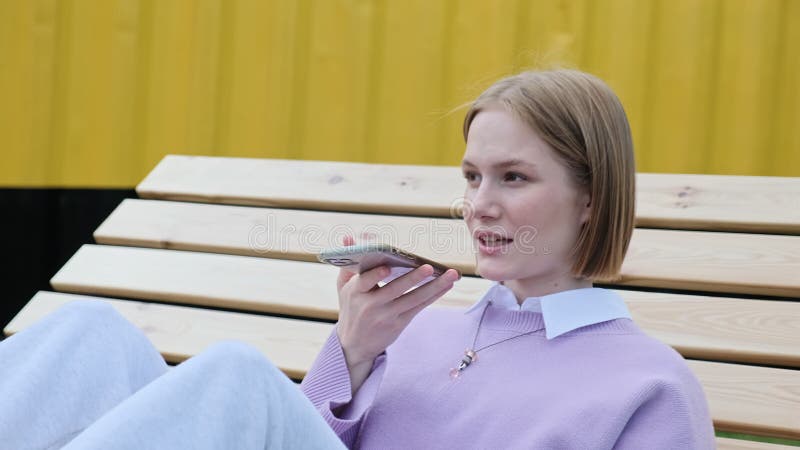 Jeune femme blonde enregistre le message vocal sur smartphone clips vidéos