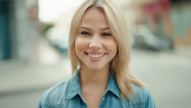 Jeune femme blonde souriante confiante debout dans la rue photos stock