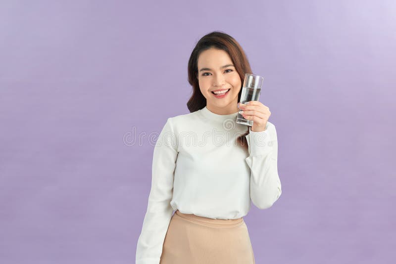 Jeune femme boire de l'eau claire fraîche et pure du verre photos stock