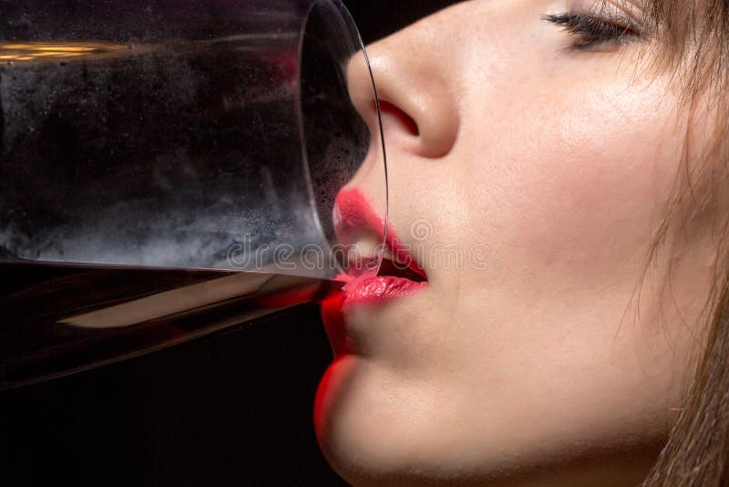 Jeune femme buvant du vin rouge d'un verre photos stock Jeune femme buvant du vin rouge d'un verre photos stock
