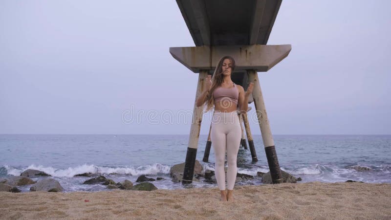 Jeune femme calme et sereine finit le yoga asana pratique à la plage.