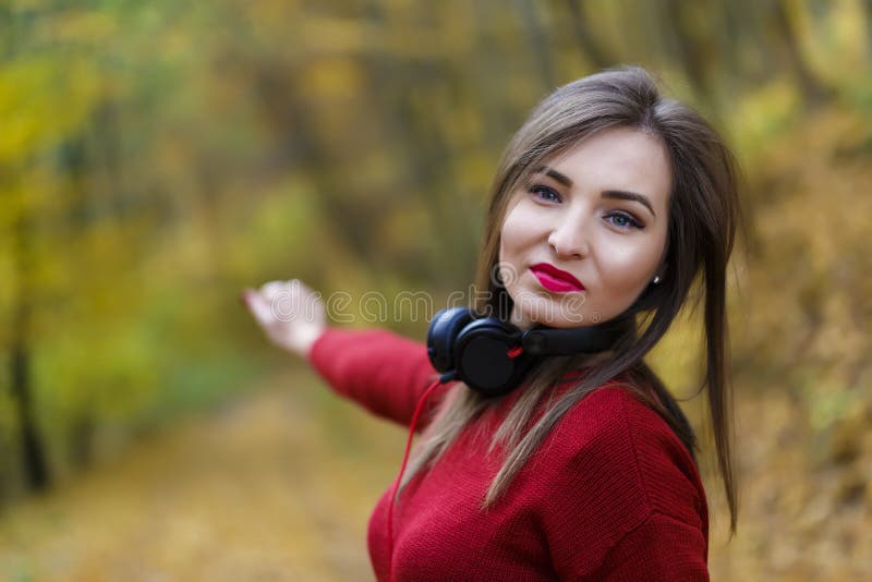 Jeune femme caucasienne de brune avec des écouteurs dehors sur l'autum image stock Jeune femme caucasienne de brune avec des écouteurs dehors sur l'autum image stock