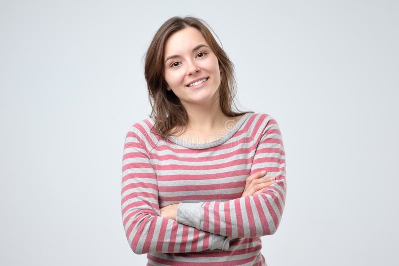 Jeune femme caucasienne de sourire avec ses bras pliés photos stock Jeune femme caucasienne de sourire avec ses bras pliés photos stock