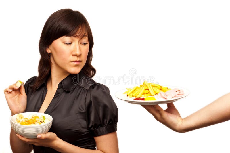 Jeune femme choisissant entre la salade saine et fri