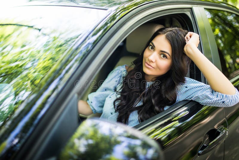 Jeune femme conduisant une voiture dans la ville Portrait d'une belle femme dans une voiture, regardant hors de la fenêtre et du images stock Jeune femme conduisant une voiture dans la ville Portrait d'une belle femme dans une voiture, regardant hors de la fenêtre et du images stock