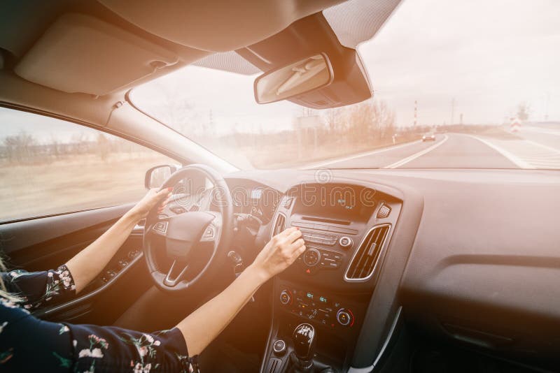 Jeune femme conduisant une voiture et ajustant l'audio de voiture photographie stock Jeune femme conduisant une voiture et ajustant l'audio de voiture photographie stock