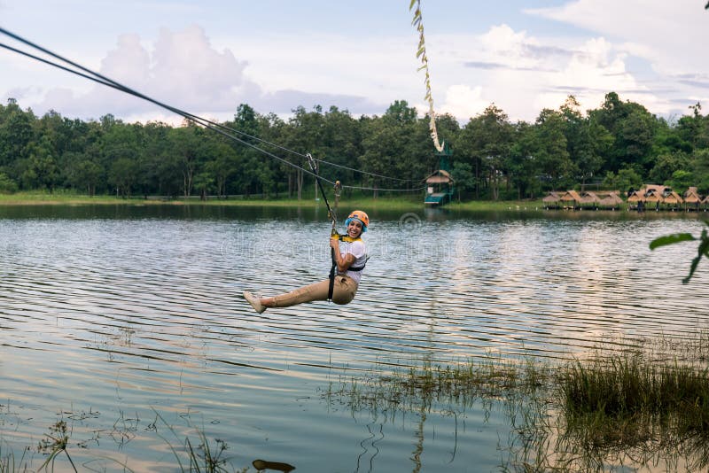 Jeune femme croisant un lac dans la ligne de fermeture éclair en Chiang Mai image libre de droits Jeune femme croisant un lac dans la ligne de fermeture éclair en Chiang Mai image libre de droits
