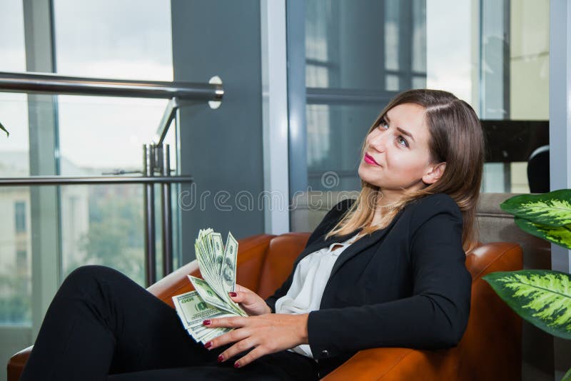 Jeune femme d'affaires attirante comptant des dollars et le sourire d'argent photographie stock Jeune femme d'affaires attirante comptant des dollars et le sourire d'argent photographie stock