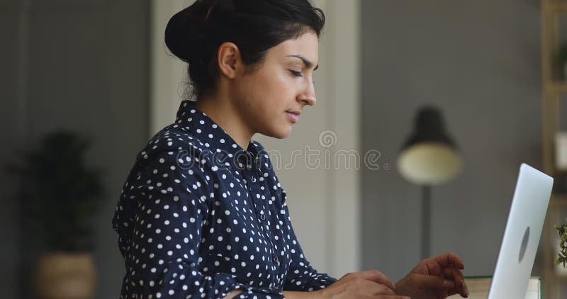 Jeune femme d'affaires indienne concentrée travaillant dans l'informatique à la maison de bureau. banque de vidéos