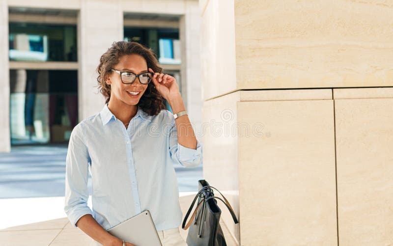 Jeune femme d'affaires tenant ses lunettes photographie stock libre de droits Jeune femme d'affaires tenant ses lunettes photographie stock libre de droits