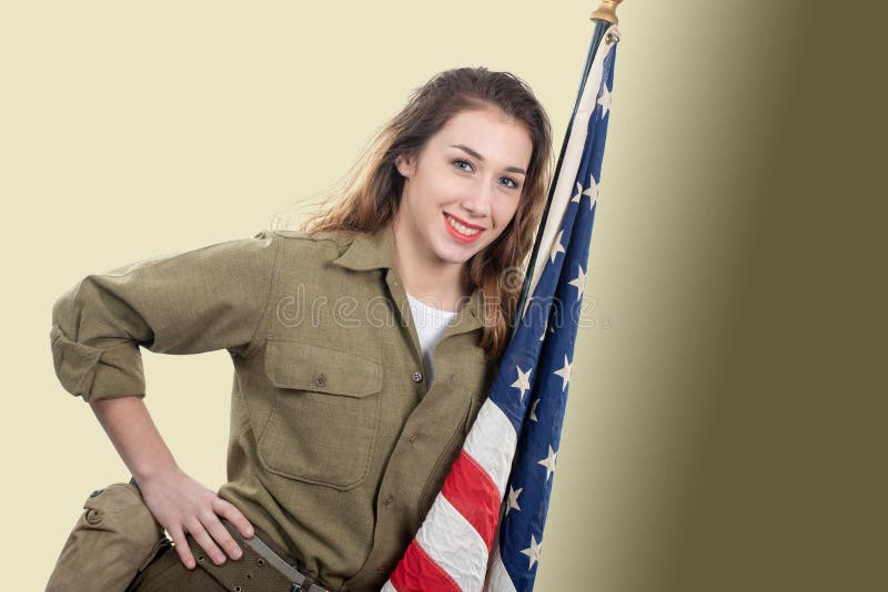 Jeune femme dans l'uniforme militaire des USA supportant un drapeau américain photos libres de droits Jeune femme dans l'uniforme militaire des USA supportant un drapeau américain photos libres de droits