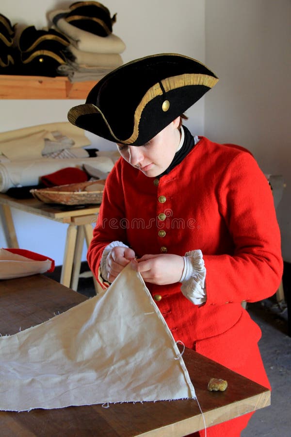 Jeune femme dans le costume de l'époque comme tailleur, fort Ticonderoga, New York, 2015 photo stock Jeune femme dans le costume de l'époque comme tailleur, fort Ticonderoga, New York, 2015 photo stock