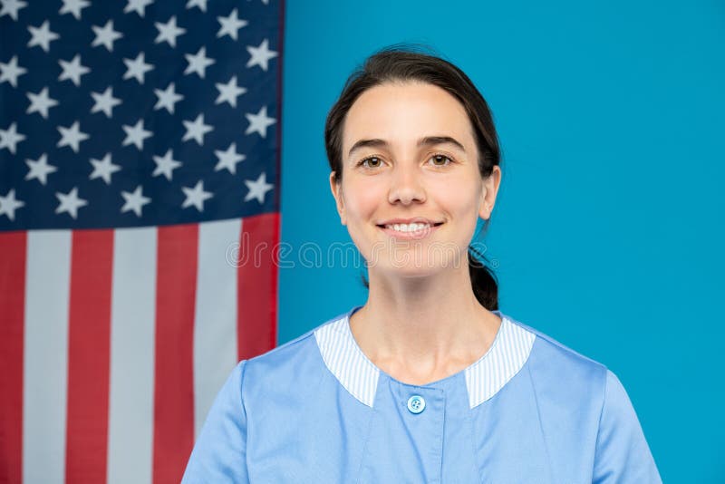 Jeune femme de chambre sécurisée en uniforme bleu qui vous regarde avec le sourire image libre de droits