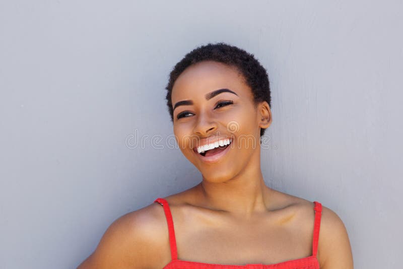 Femme Attirante Souriant Avec La Main Dans Les Cheveux Sur Le Fond Gris