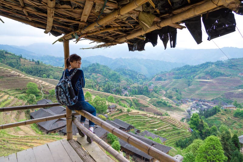 Jeune femme de déplacement avec le sac à dos sur le fond du te de riz images stock Jeune femme de déplacement avec le sac à dos sur le fond du te de riz images stock