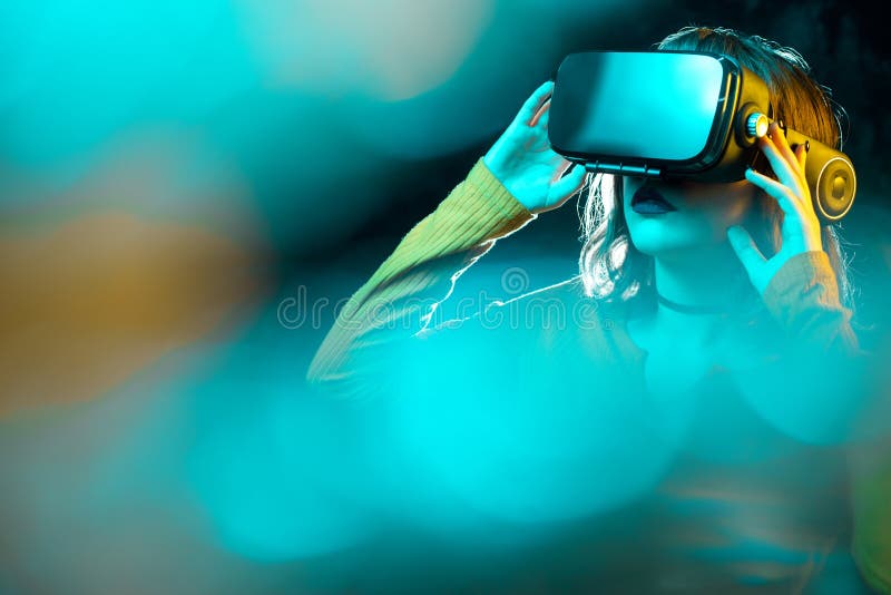 Jeune femme de hippie avec les lunettes de port de r?alit? virtuelle de cheveux boucl?s et toucher un autre monde dans les lampes image stock Jeune femme de hippie avec les lunettes de port de r?alit? virtuelle de cheveux boucl?s et toucher un autre monde dans les lampes image stock