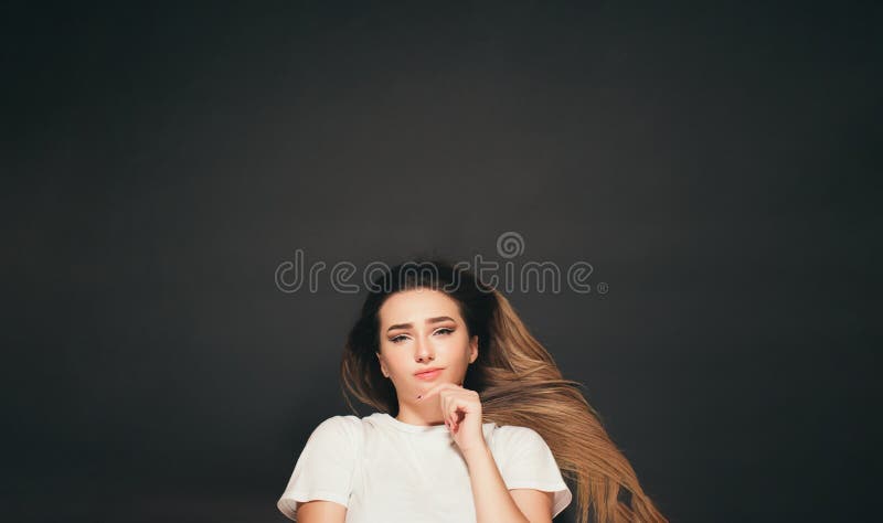 Jeune femme de pensée avec de longs cheveux se trouvant sur la vue de dessus de fille confuse de fond de studio images libres de droits