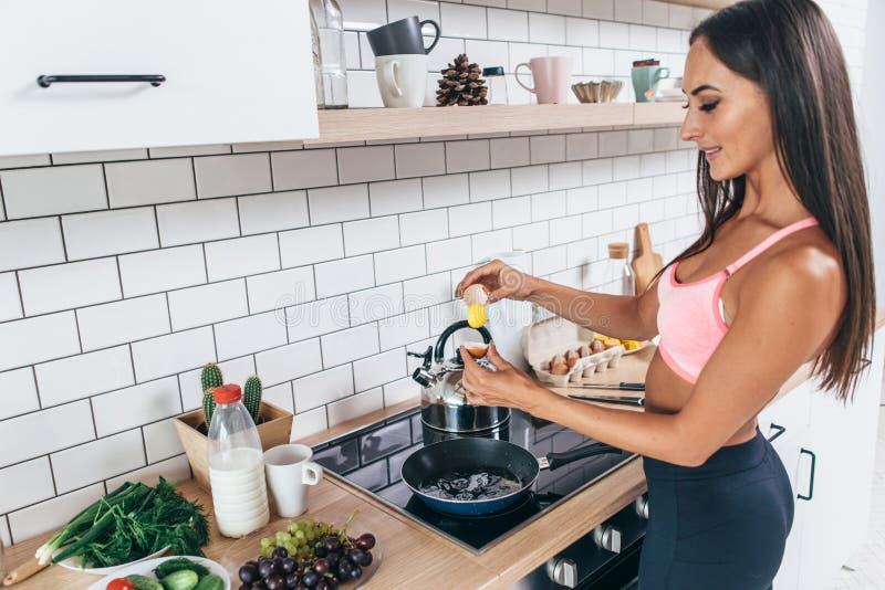 Jeune femme de sourire préparant le régime, la forme physique et le bien-être sains de petit déjeuner image stock Jeune femme de sourire préparant le régime, la forme physique et le bien-être sains de petit déjeuner image stock