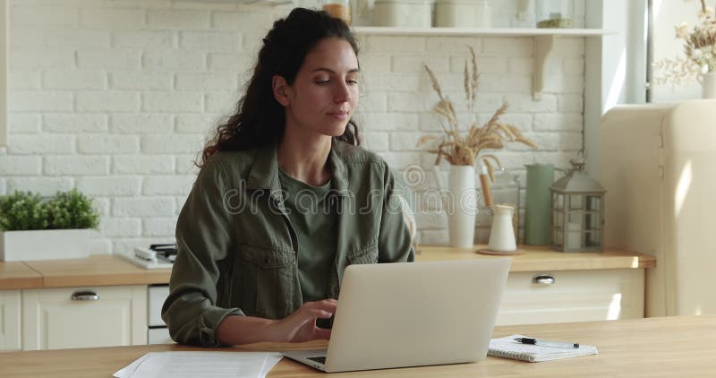 Jeune femme de sourire réfléchie travaillant sur l'ordinateur. banque de vidéos