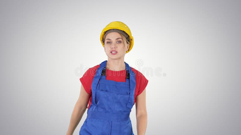 Jeune femme de sourire de travailleur parlant et montrant des objets à ses côtés sur le fond de gradient banque de vidéos