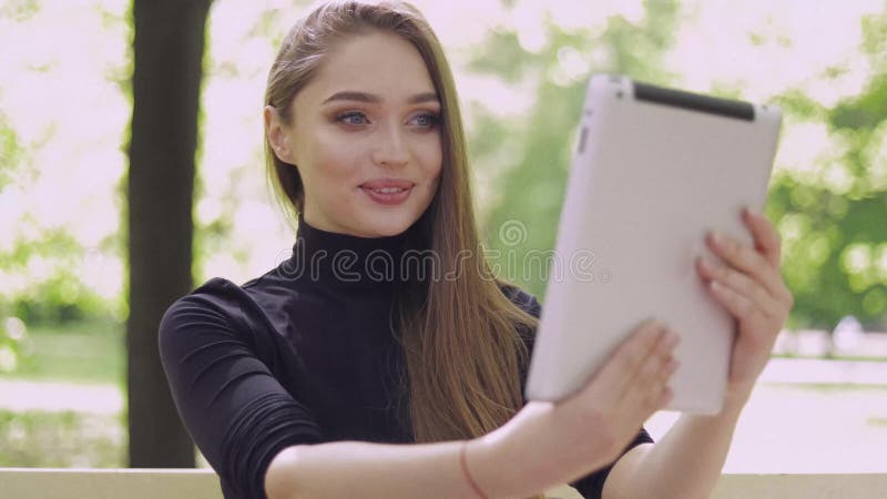 Jeune femme de sourire à l'aide du comprimé de conversation en ligne clips vidéos