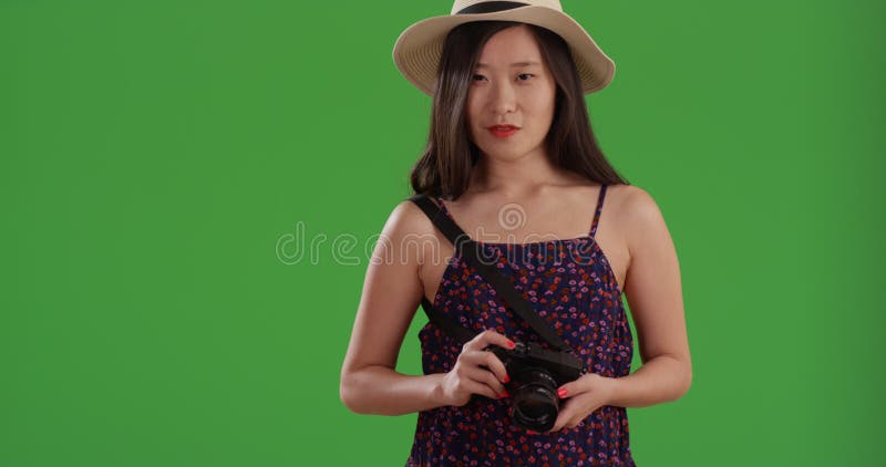 Jeune femme de tourisme joyeuse prenant des photos avec caméra devant greenscreen banque de vidéos